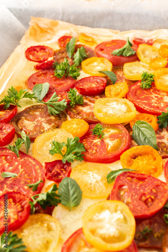 Puff pastry pie with colorful tomatoes and mozzarella, parsley and basil