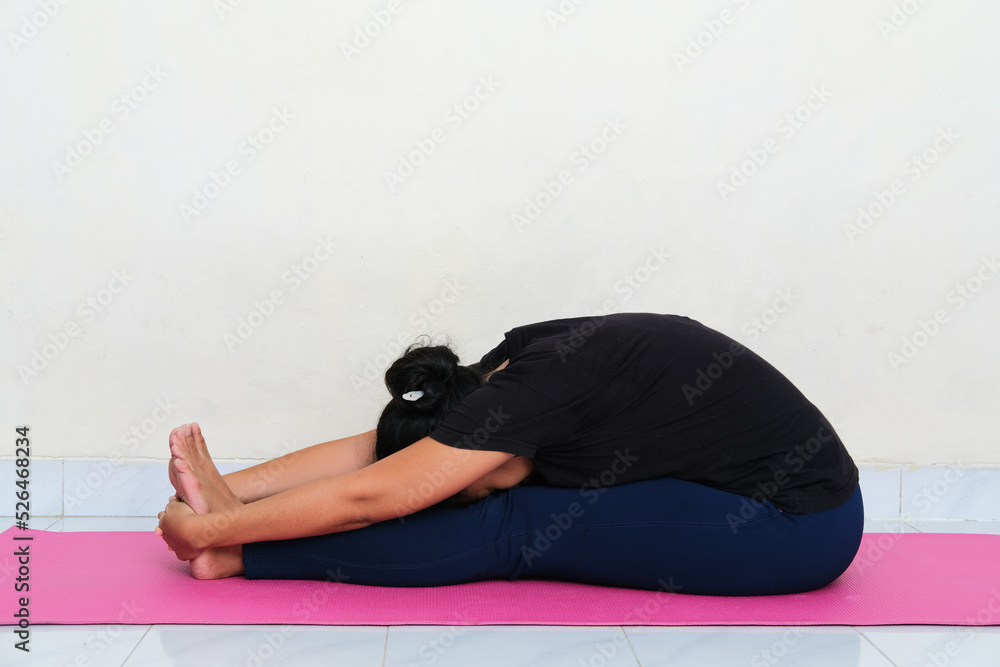 Young Asian woman doing yoga pose above sport mattress Young Asian woman doing yoga pose above sport mattress