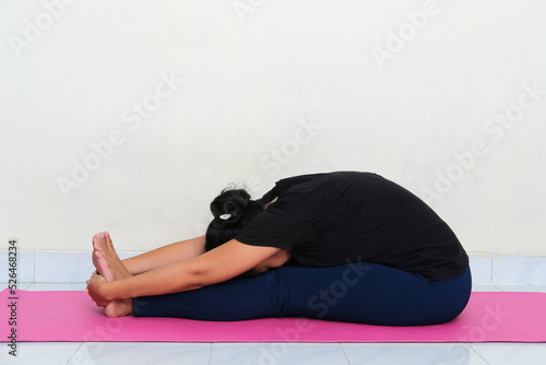 Young Asian woman doing yoga pose above sport mattress