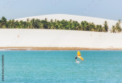 Brasil, Jericoacoara white beach with surfer photo