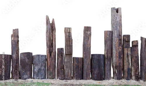 Isolation of a decayed wooden stump, which is installed as an artifical fence on the sand in the garden.