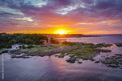 Fotografie aerial view of svaneke lighthouse at sea coast during sunset on bornholm denmark