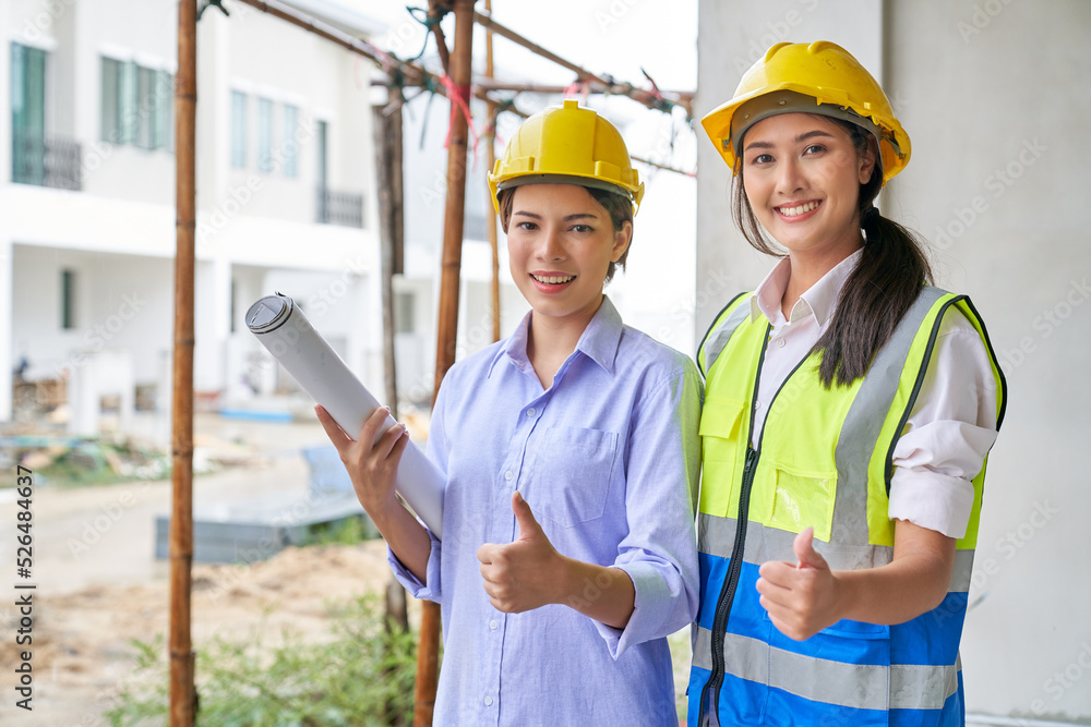 Two female in foreman uniform are trumbing up on construction site Two female in foreman uniform are trumbing up on construction site