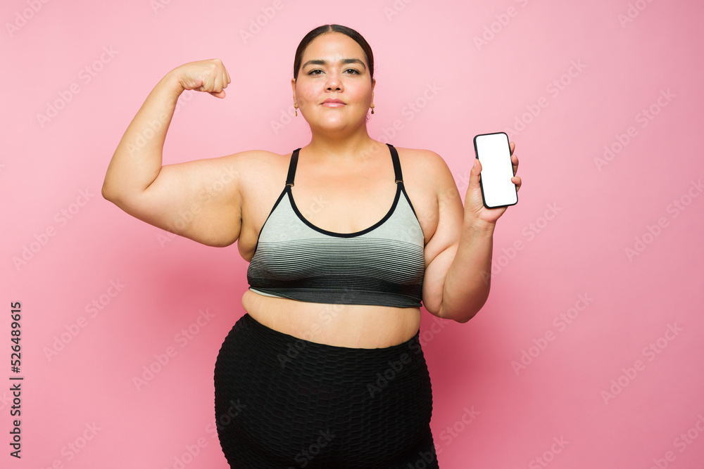 Hispanic fat woman happy to do a fitness workout using her smartphone Hispanic fat woman happy to do a fitness workout using her smartphone