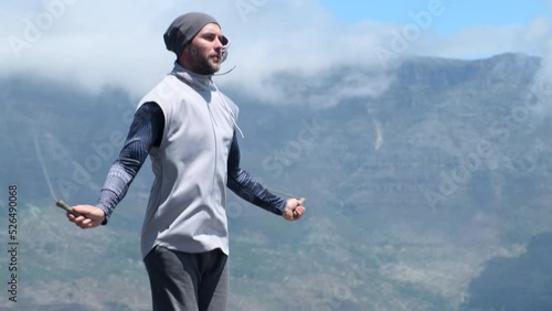 Wallpaper Mural stylish man in sportswear jumping rope in the mountains. fitness, sport and exercising concept - man skipping with jump rope outdoors. Smiling american man in sportswear with fitness tracker jumping Torontodigital.ca