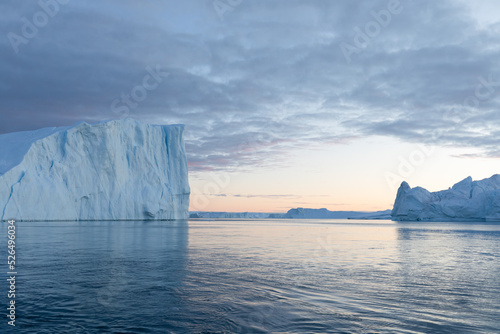 Climate change and global warming. Icebergs from a melting glacier in Greenland. The icy landscape of the Arctic nature in the UNESCO world heritage site. Summer season