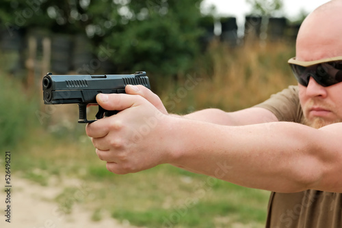 a man threatens with a combat pistol. man holding a gun in his hands