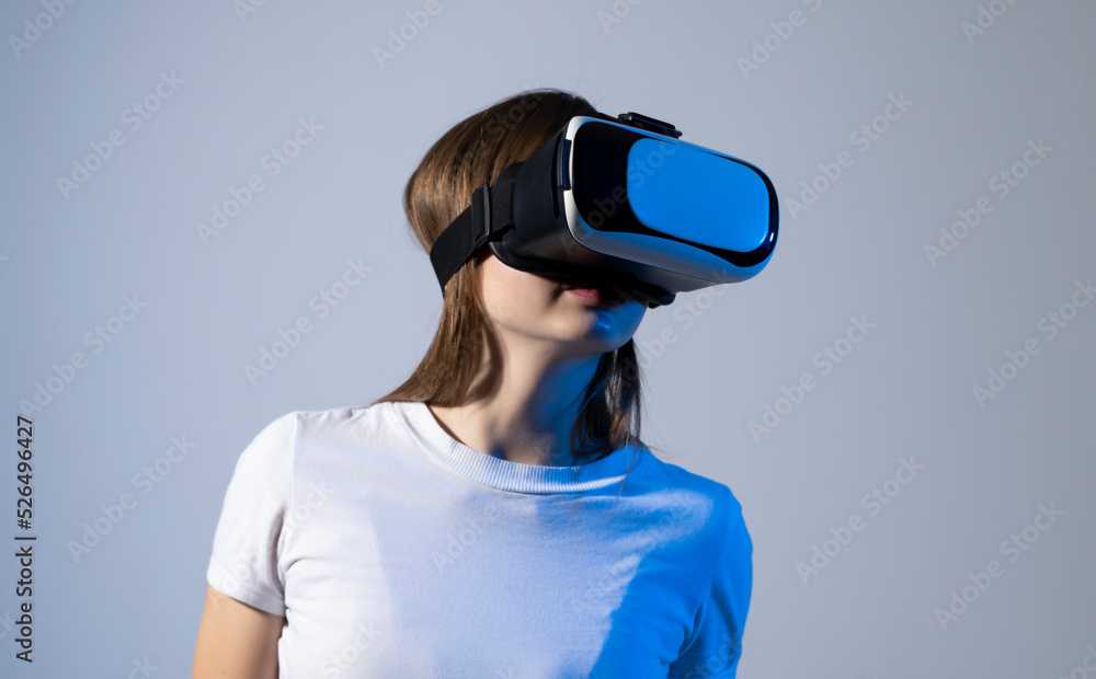 Young woman working in VR goggles on a grey background. Modern architect using virtual reality glasses at workplace. Designer working in augmented reality vr studio. Young woman working in VR goggles on a grey background. Modern architect using virtual reality glasses at workplace. Designer working in augmented reality vr studio.