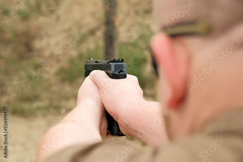 a man threatens with a combat pistol. man holding a gun in his hands