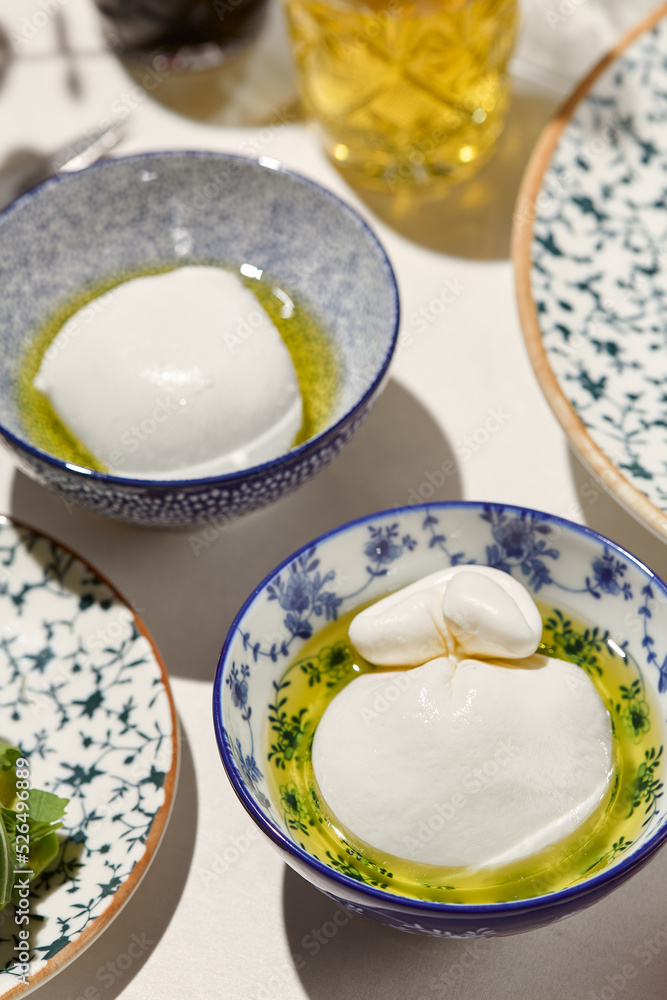 Aesthetic composition with burrata cheese and mozzarella in olive oil. Fresh burrata and