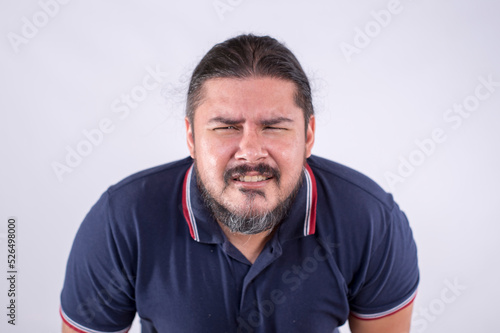 A guy in his late 30s squinting and straining his eyes in an attempt to focus clearly at something. Deteriorating eyesight and blurry vision. Isolated on a white backdrop.