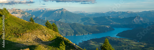 Magnificent panorama of a mountain landscape at an altitude of 2140 m with a sublime view of the large "Serre-Ponçon" lake in the middle of the valley. End of the day, in the Southern Alps, in France.