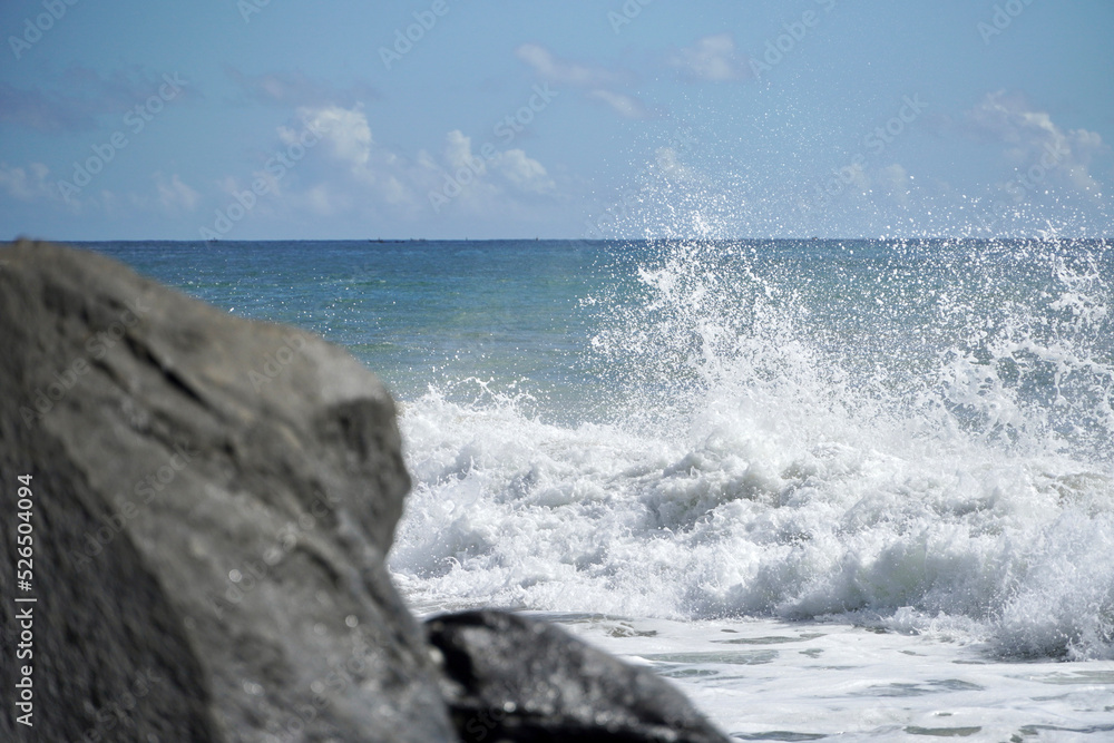 Ocean waves crashing on sandy beach. Sea waves breaking on shore. Nature splash on summer day. Sea wave crashing on beach. Coastal storm and storm weather concept. Splashing sea water with foam.