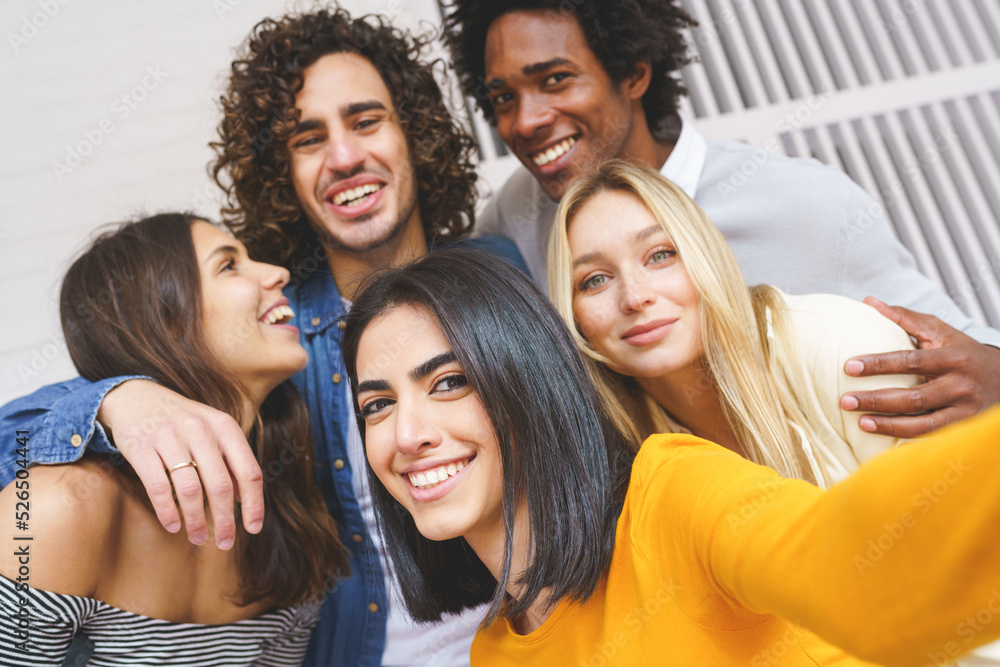 Obraz premium Company of multiethnic friends taking selfie