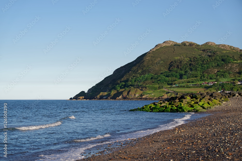 Seascape with calm sea, beach and famous Bray Head mountain on sunny summer day in Bray, Ireland Seascape with calm sea, beach and famous Bray Head mountain on sunny summer day in Bray, Ireland