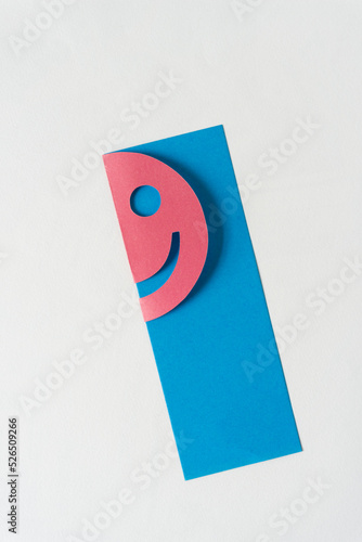 half smiley stuck on blue paper