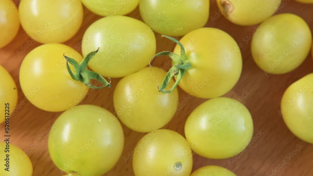 Ripe yellow organic small cherry tomatoes rotate on wooden board top view. Delicious summer vegetable, healthy food, diet, salad ingredient. Tomatoes close up. Eco product. Footage 4K Ripe yellow organic small cherry tomatoes rotate on wooden board top view. Delicious summer vegetable, healthy food, diet, salad ingredient. Tomatoes close up. Eco product. Footage 4K