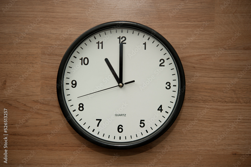office wall clock indicating the eleven o clock hour office wall clock indicating the eleven o clock hour