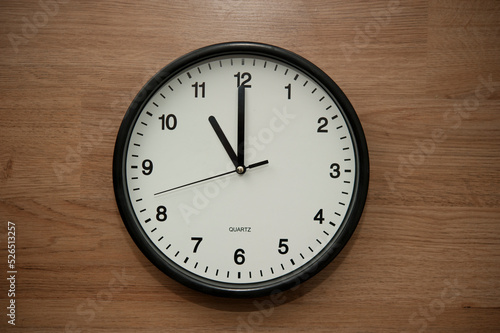 office wall clock indicating the eleven o clock hour
