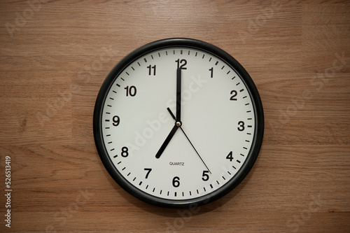 office wall clock indicating the seven o clock hour
