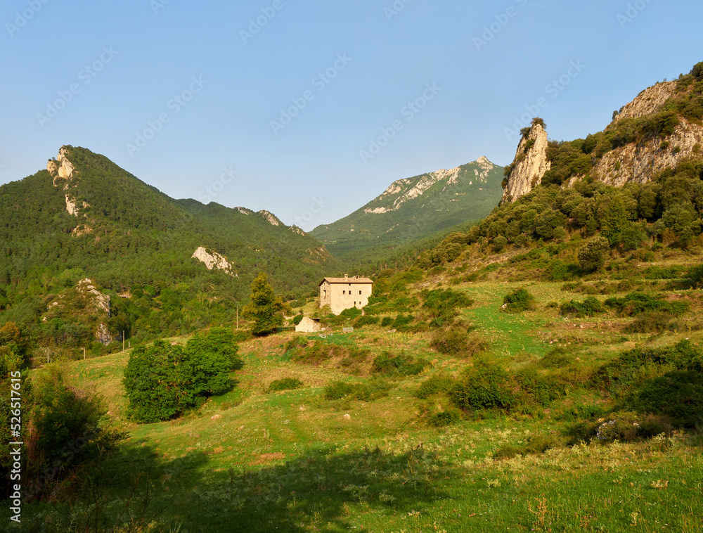 house surrounded by mountains and green meadows
