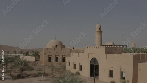 Drone flight over abandoned city with mosque in the desert..
