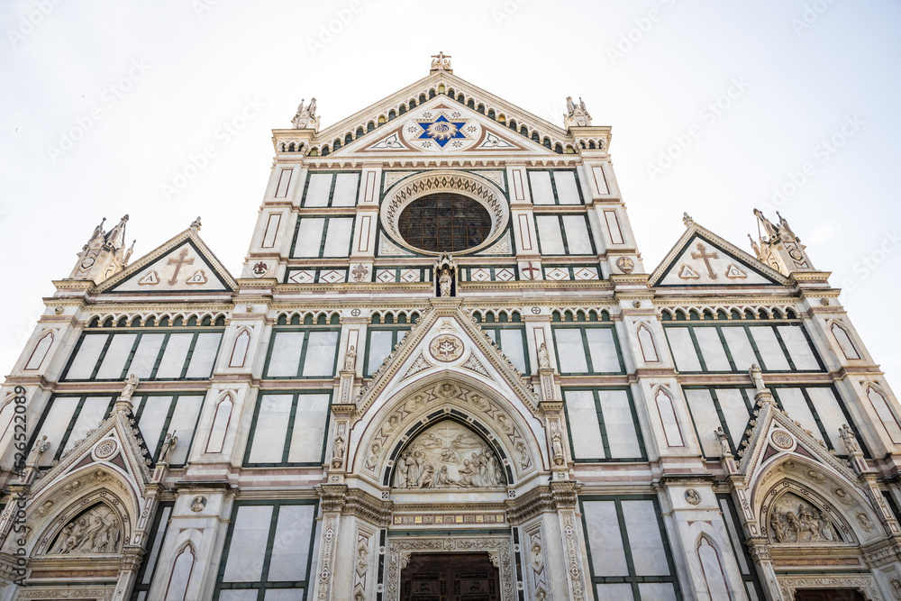 The façade of a gothic style church in the city of Florence Italy in bright daylight.