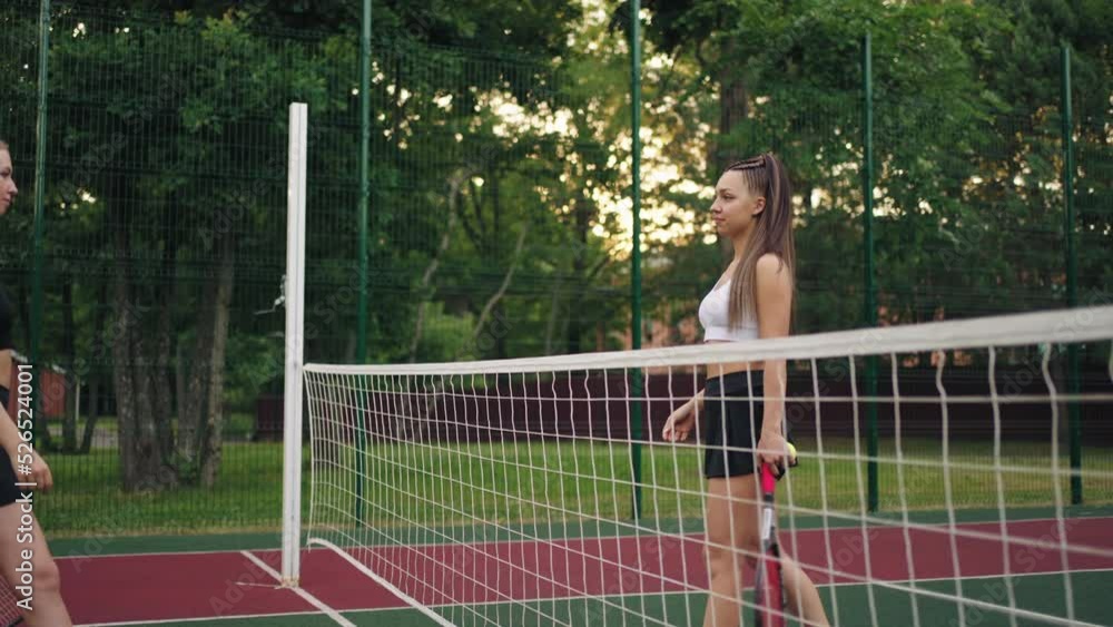 two female tennis player are welcoming each other on court, shaking hands and going to place two female tennis player are welcoming each other on court, shaking hands and going to place