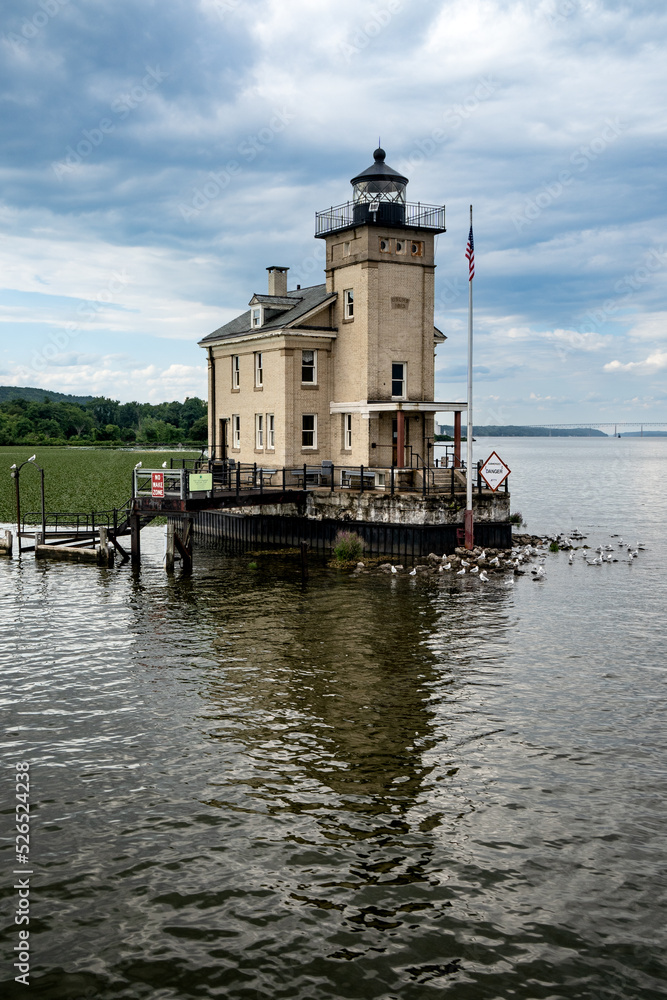 Kingston, NY – USA – Aug 2, 2022 Horizontal view of the historic Rondout Light, a lighthouse consisting of a square tower and attached to a rectangular, two-story dwelling. Built on the Hudson River. Kingston, NY – USA – Aug 2, 2022 Horizontal view of the historic Rondout Light, a lighthouse consisting of a square tower and attached to a rectangular, two-story dwelling. Built on the Hudson River.
