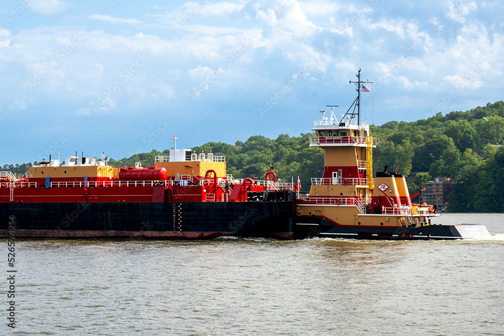 Kingston, NY – USA – Aug 2, 2022 Horizontal view of the HAGGERTY GIRLS, a Pusher Tug, built in 2013 pushing a barge down the Hudson River.