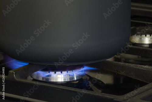 A black pan cooking on natural gas.