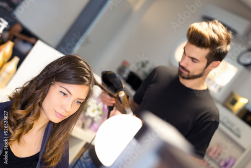 Young woman getting new hairstyle from hairdresser in the modern hair salon