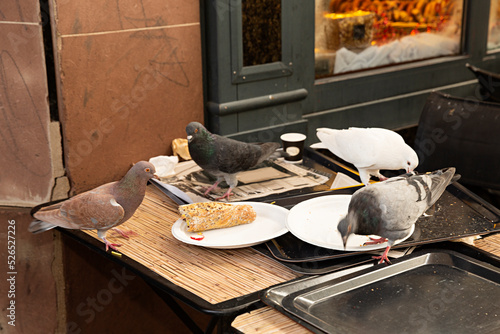 Palomas comiendo restos de comida en un restaurante.