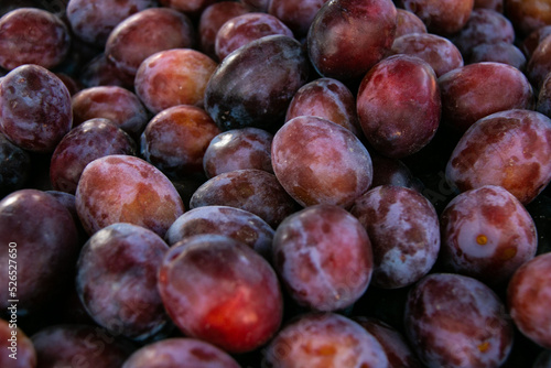 Background of ripe fresh plums. Close-up. Sale of plums at the farmers' market.