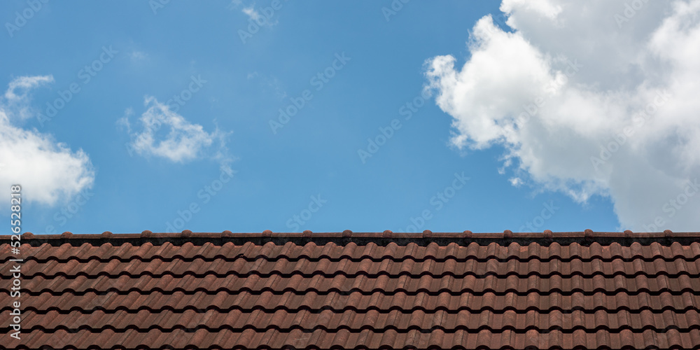 Old red roof tiles on blue sky with clouds background. Old red roof tiles on blue sky with clouds background.