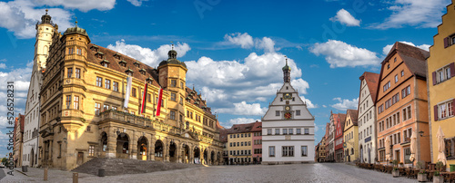 Der zentrale Marktplatz in der historischen Altstadt von Rothenburgg ob der Tauber mit seinen historischen Gebäuden bei sonnigem Wetter und aufgelockerter Bewölkung