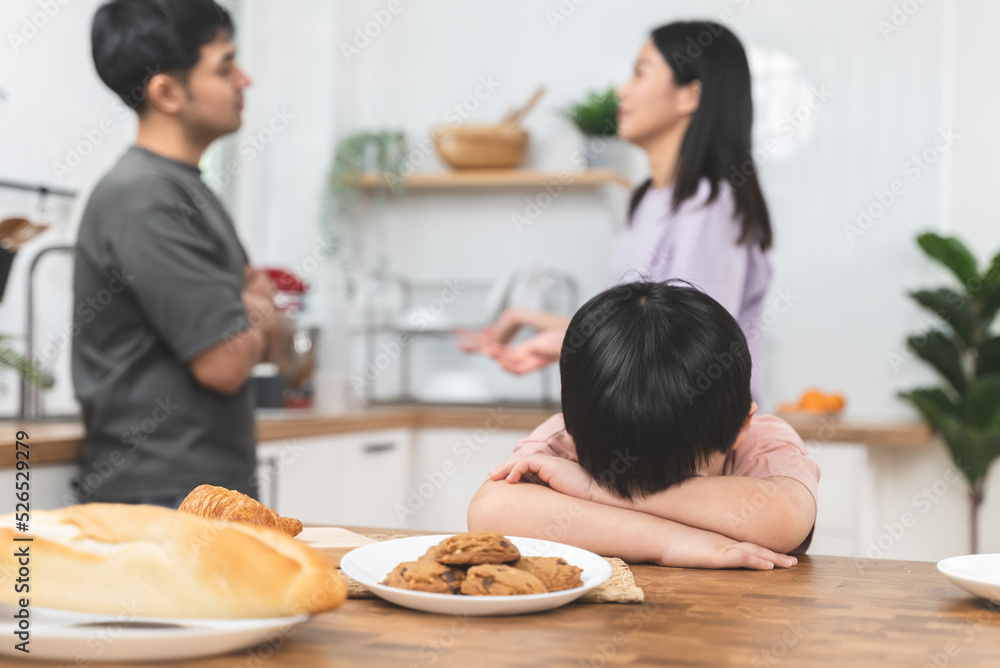 domestic violence. Stressed Asian kid covering his face after mom and dad started arguing. domestic violence. Stressed Asian kid covering his face after mom and dad started arguing.