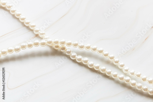 Pearl necklace on a marble background with copy space.