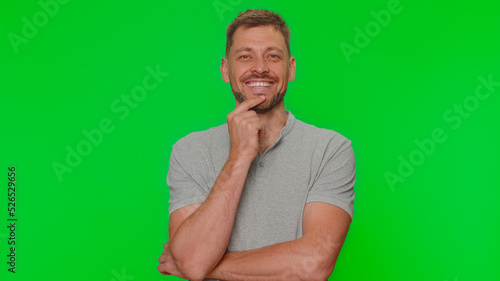 Fotografie Portrait of happy bearded handsome young man in gray t-shirt looking at camera, smiling