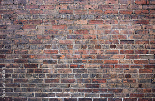 An old red brick wall with a grungy style.