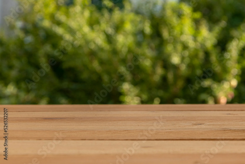 Wooden table with free space for your product or advertising text. Landscape of greenery of nature.