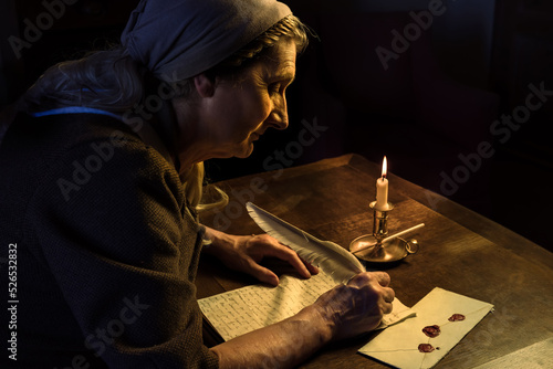 Woman at vintage desk writing a letter with a feather quill 