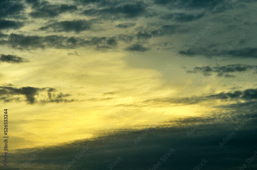 sunset sky with yellow lights and dark mottled clouds
