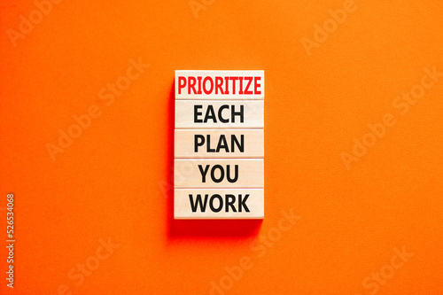 Prioritize each plan you work symbol. Concept words Prioritize each plan you work on wooden blocks on beautiful orange background. Business prioritize each plan you work concept. Copy space