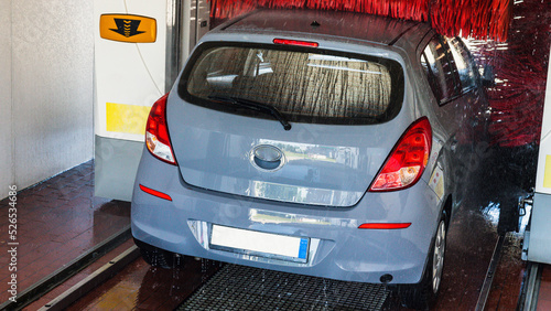 Automatic car wash. Auto brush washer clean blue car on automatic carwash station. Automatic car wash cleaning service.