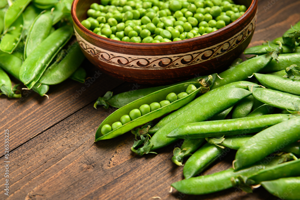 green sweet peas on a dark wooden background, still life, concept of fresh and healthy food green sweet peas on a dark wooden background, still life, concept of fresh and healthy food