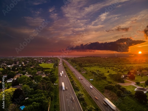 Drone view of the Port Hope streets surrounded by buildings and nature during a colorful sunset photo