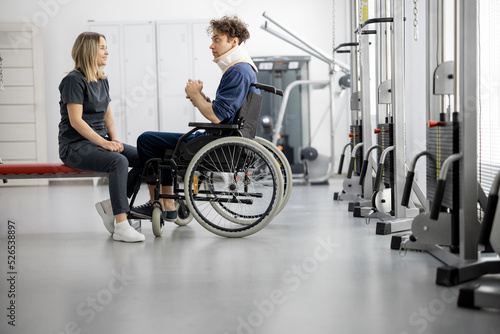 Rehabilitation specialist talking with a guy on wheelchair at rehabilitation center. Concept of mental health and recovery after injuries