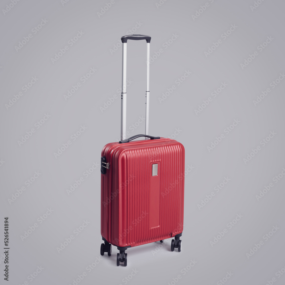 Red rolling suitcase on gray background Red rolling suitcase on gray background