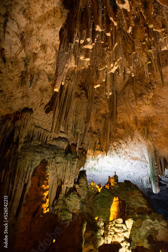Horizontal view of the ceiling and floor of a cave with a close-up of stalagtites and stalagmites. photo